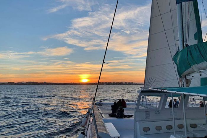 ></center></p><ul><li>Description & Reviews</li><li>Prices & Details</li></ul><p>Whether enjoying a romantic moment or having fun with friends and family, our Sunset Catamaran Cruises are a great way to end your afternoon.</p><p>The catamaran tours are popular and can book out many weeks in advance. Don't leave it until the last minute. Book now!</p><h2>See all our Valencia sailing options here</h2><p>This cruise departs  Valencia's marina  between 4:30pm and 8pm, depending on time of year, see the full schedule here .</p><p>As you board our catamaran, the atmosphere and ambient music sweeps over you and you'll start to feel the calming effect of the sea.</p><p>TIP! Include drinks vouchers when you book and save time and money onboard!</p><p>Imagine this special moment, relaxing on the deck with friends and loved-ones, sipping your complimentary glass of cava and waiting for the sun to slowly sink behind the horizon.</p><p>With the red-orange glow in the sky growing darker and day turning to night, you can gaze at the illuminated waterfront buildings as you arrive back at port.</p><p>There is seating for everyone and a shaded area, or you can upgrade to include reserved seating in the net area at the front of the boat, were you can lay out and enjoy the sun too.</p><p>You'll be dropped back at the conveniently located pier, where you can spend the evening wandering along  La Playa de las Arenas  promenade. The perfect way to end a memorable day that you’ll surely want repeat!</p><h2>Customer Reviews</h2><blockquote>★ ★ ★ ★ ★ 